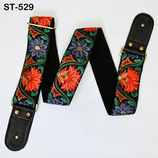 A colorful guitar strap with a floral pattern, featuring red, orange, and blue flowers, is displayed against a white background.