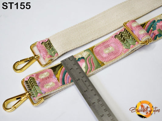 a strap with a floral pattern and a ruler placed next to it, indicating the strap's size.