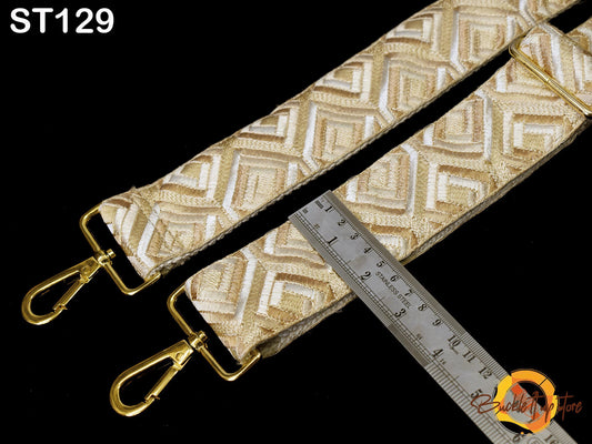 a close-up view of a gold-colored strap with a ruler placed next to it, indicating the strap's size or length.