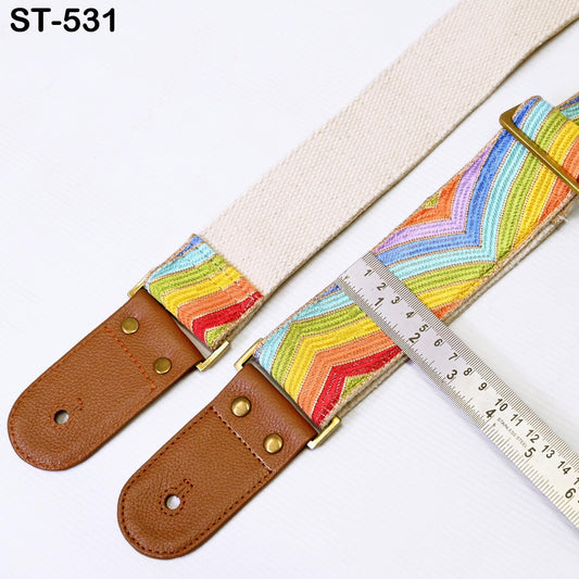 a colorful guitar strap with a ruler placed next to it, indicating the strap's length.