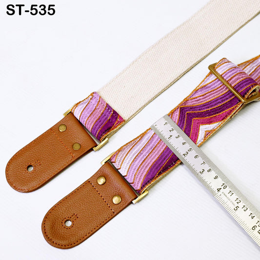 a pair of guitar straps with a ruler placed next to them, indicating the size of the straps.