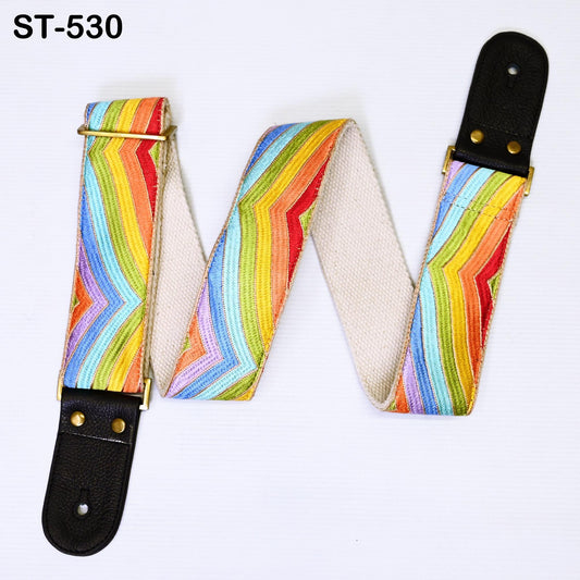 A colorful guitar strap with a rainbow pattern, featuring a black leather buckle.