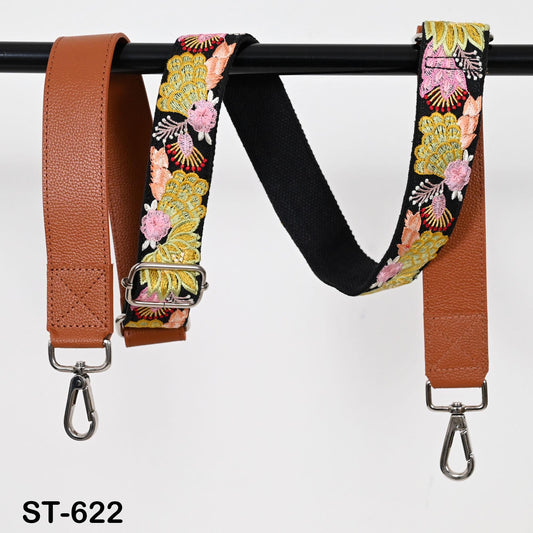 Two leather straps with floral embroidery, one brown and one black, hanging on a black rod.
