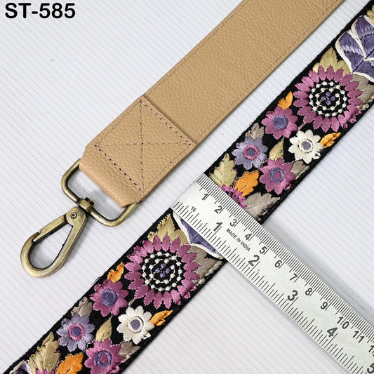 a beige strap with a floral pattern and a metal ruler placed on a white surface.