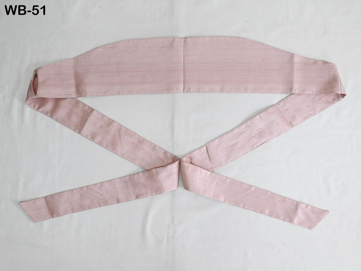 A pink fabric item, possibly a belt or scarf, is laid out on a white background.