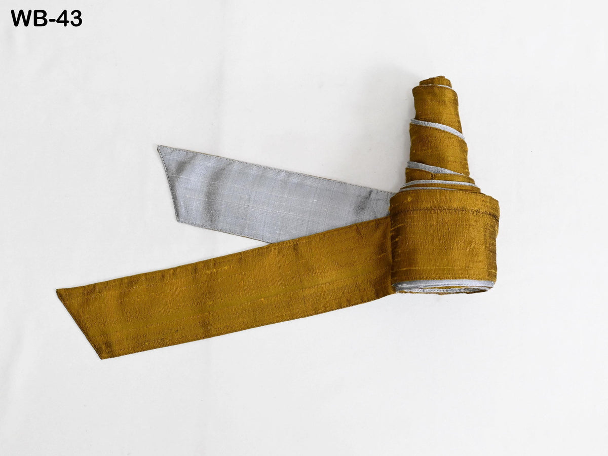 a roll of gold and silver fabric against a white background.