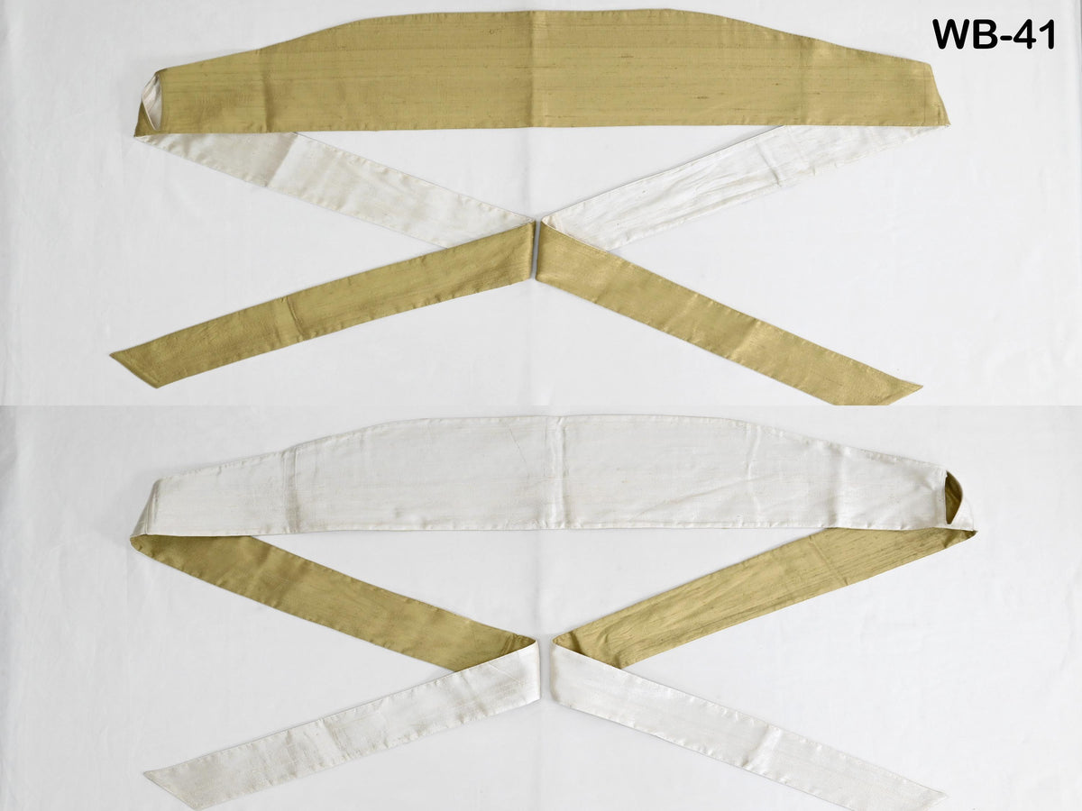 two pieces of fabric, one with a gold color and the other with a white color, arranged in a way that they appear to be tied together.