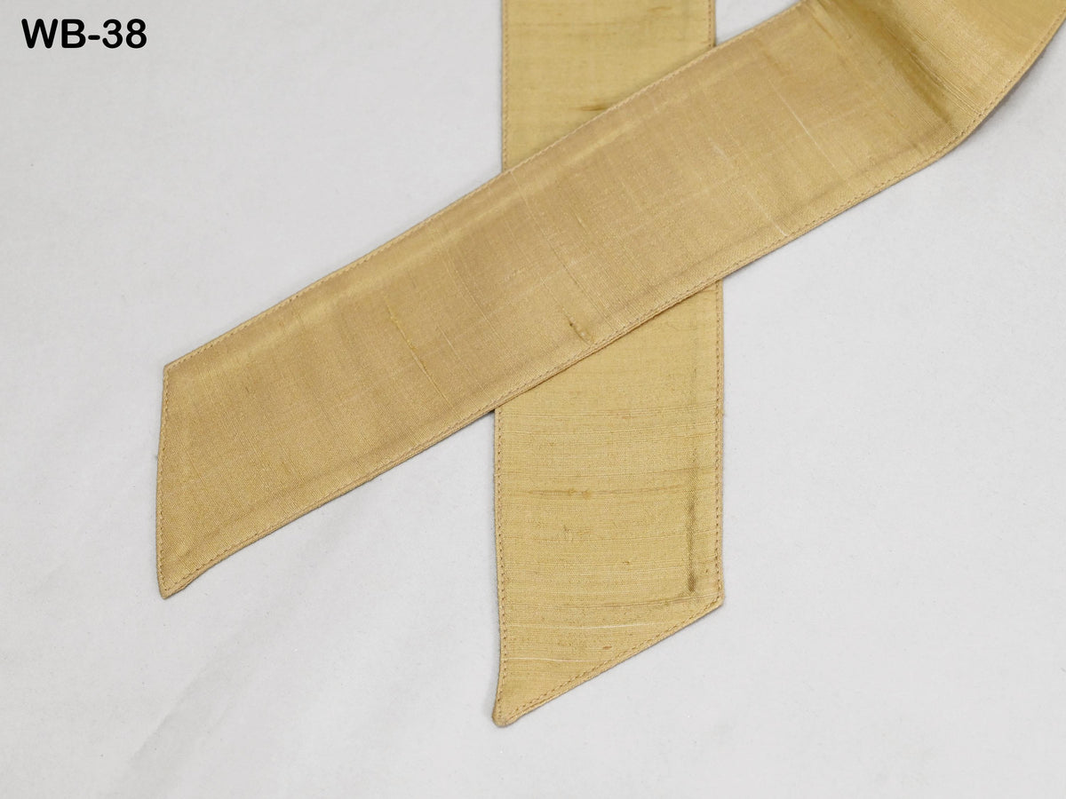 a close-up view of a gold-colored ribbon or band, with a white background.