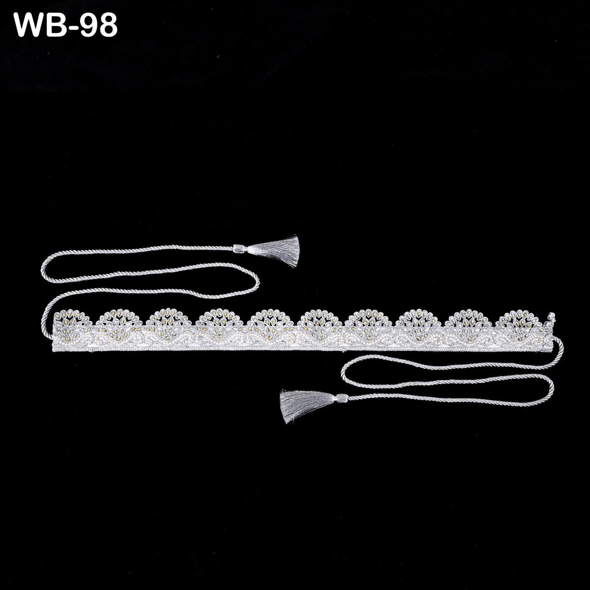 A decorative silver belt with a tassel hanging from it, set against a black background.