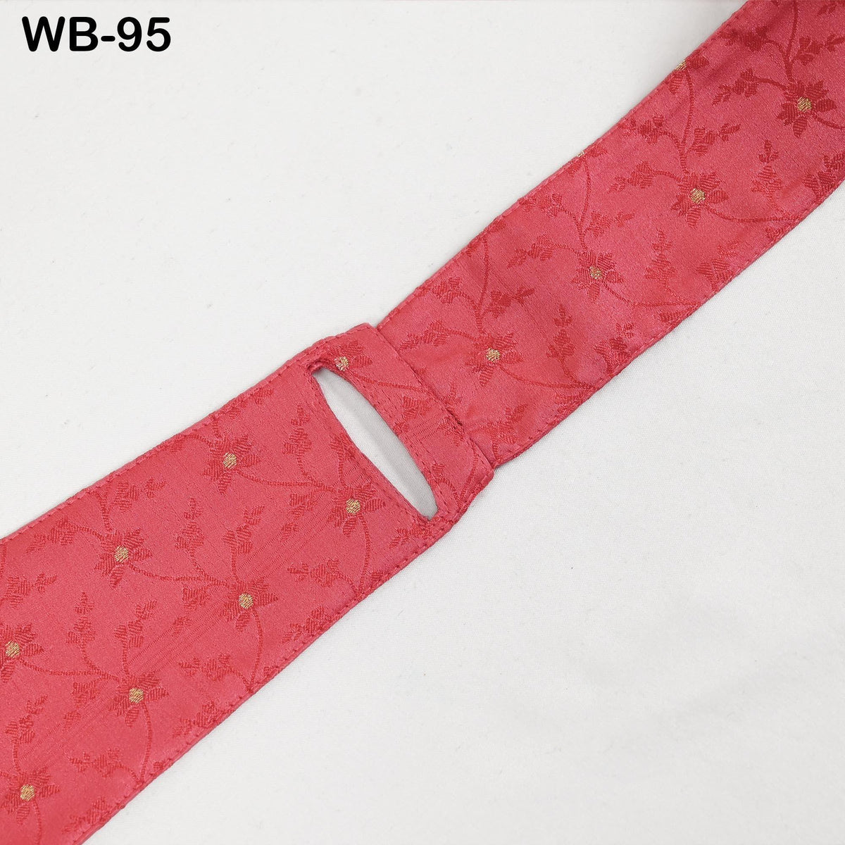 A red fabric with a floral pattern, featuring a small cut or tear in the center.