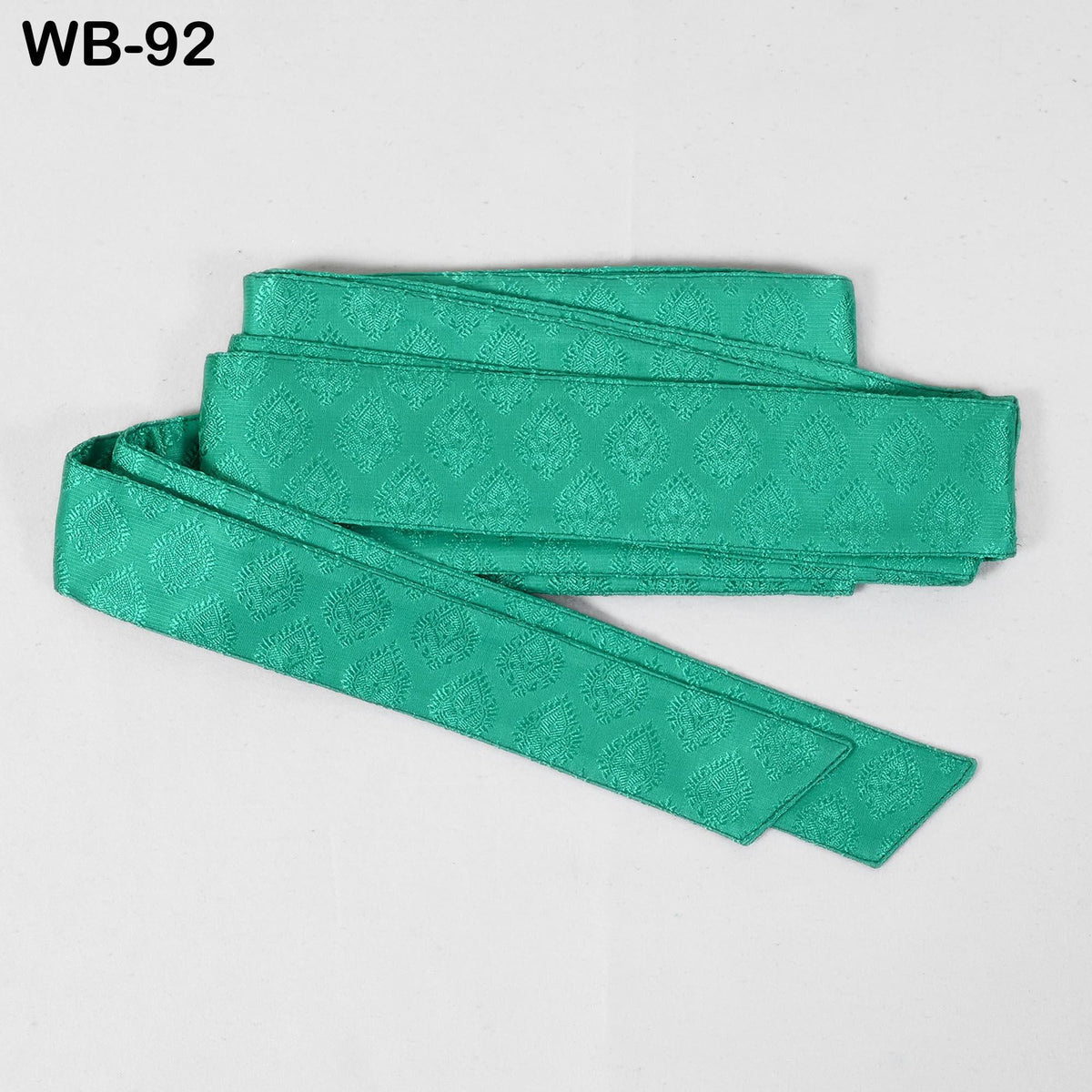 A green, patterned fabric item, possibly a tie or scarf, is shown against a white background.