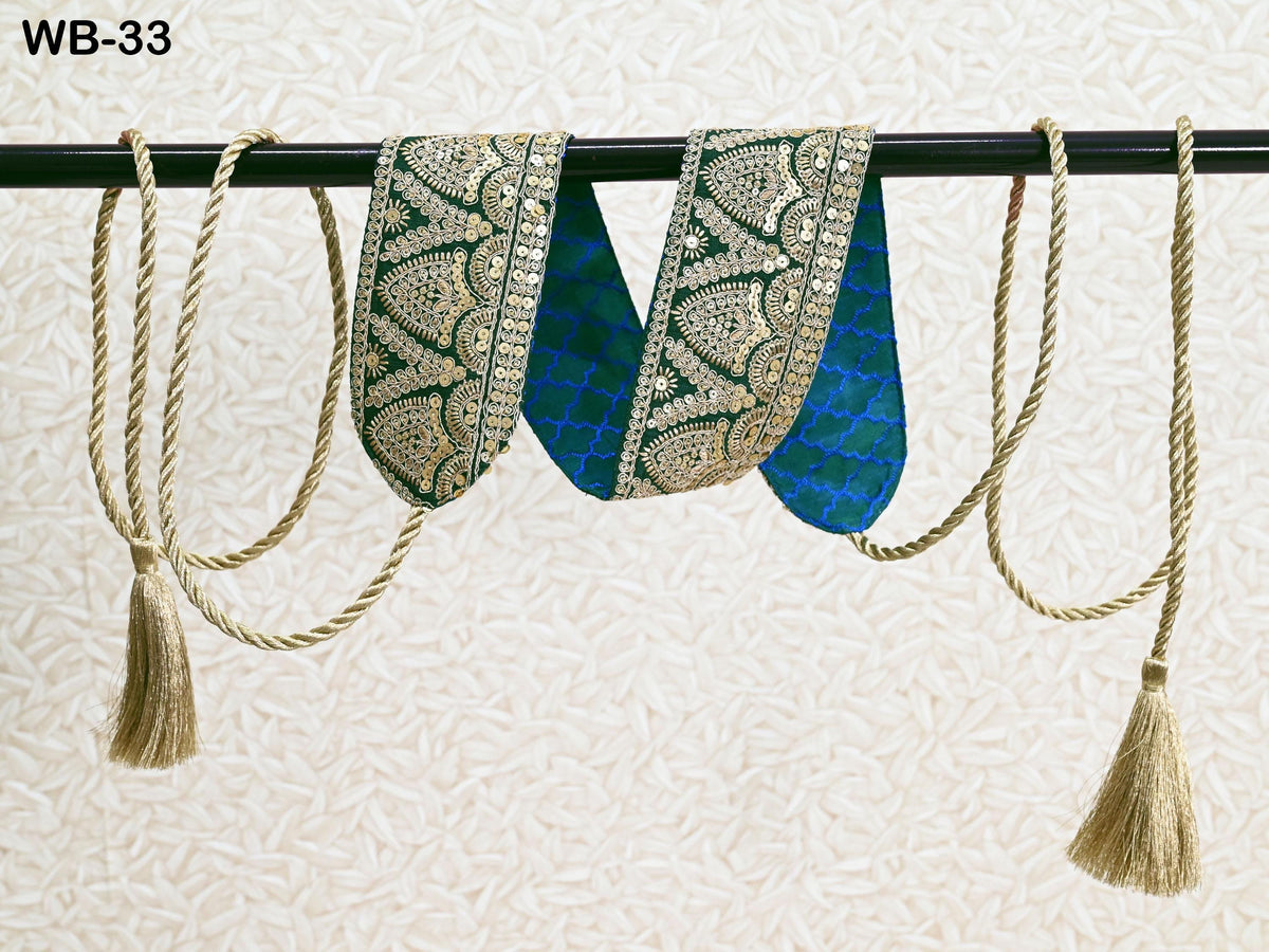 a pair of decorative fabric pieces hanging on a black rod, with tassels attached to the ends.