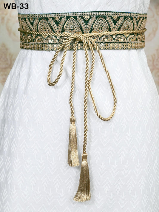 a close-up view of a white dress with a decorative gold belt featuring a tassel. The belt is tied in a bow and has a tassel hanging from the end.