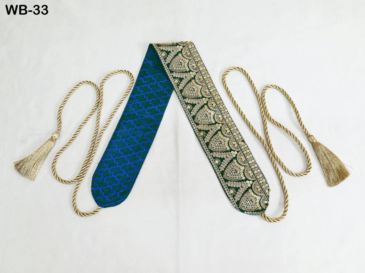 a decorative blue and green patterned fabric with gold accents, accompanied by two gold tassels.