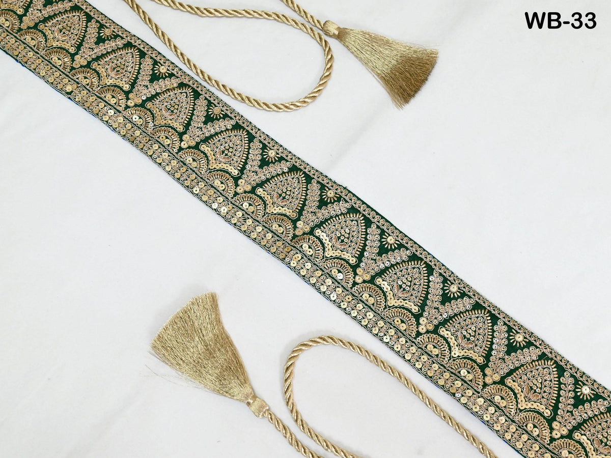 a decorative border with a repeating pattern of green and gold designs, along with two gold tassels attached to the border.