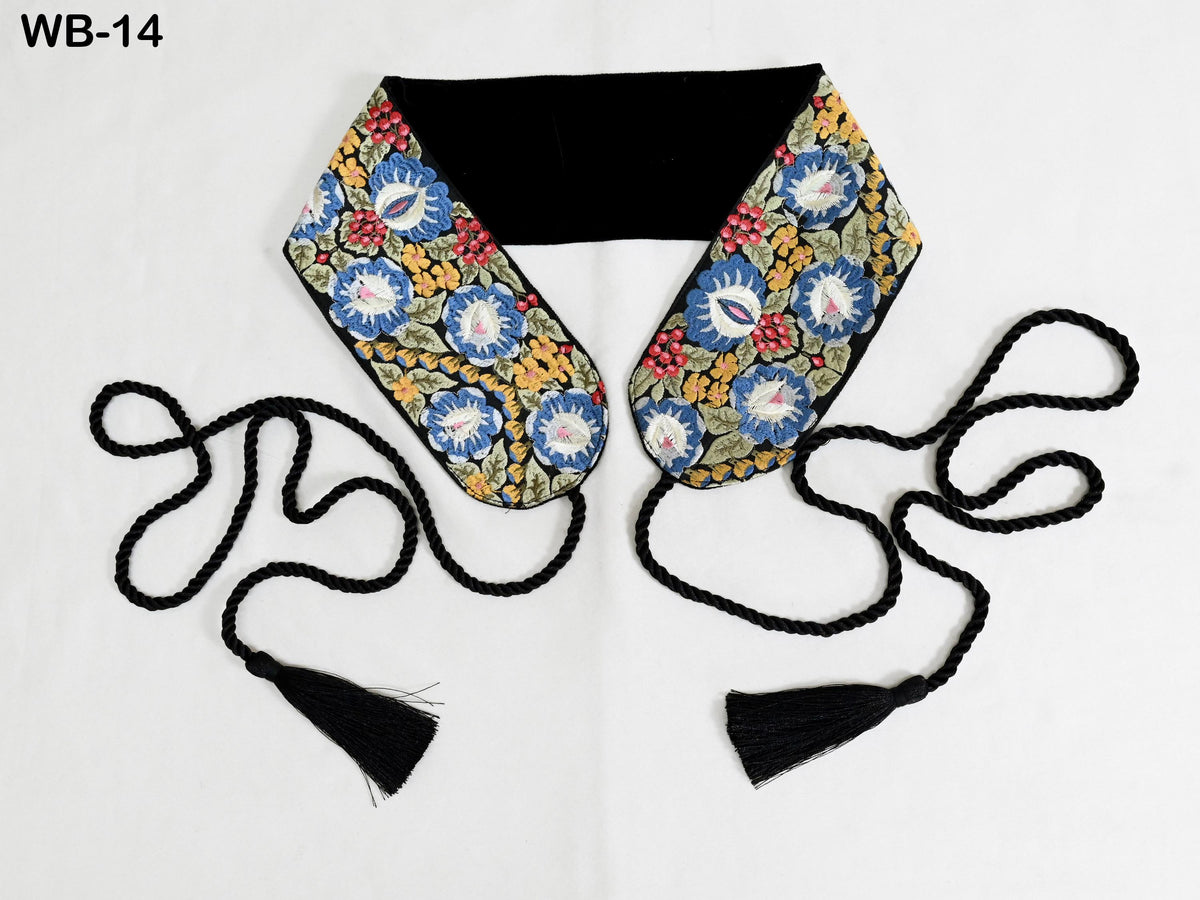 A colorful, floral-patterned scarf with black tassels, displayed on a white background.