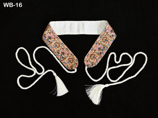 a decorative collar with a floral pattern and two white tassels, one on each side, against a black background.