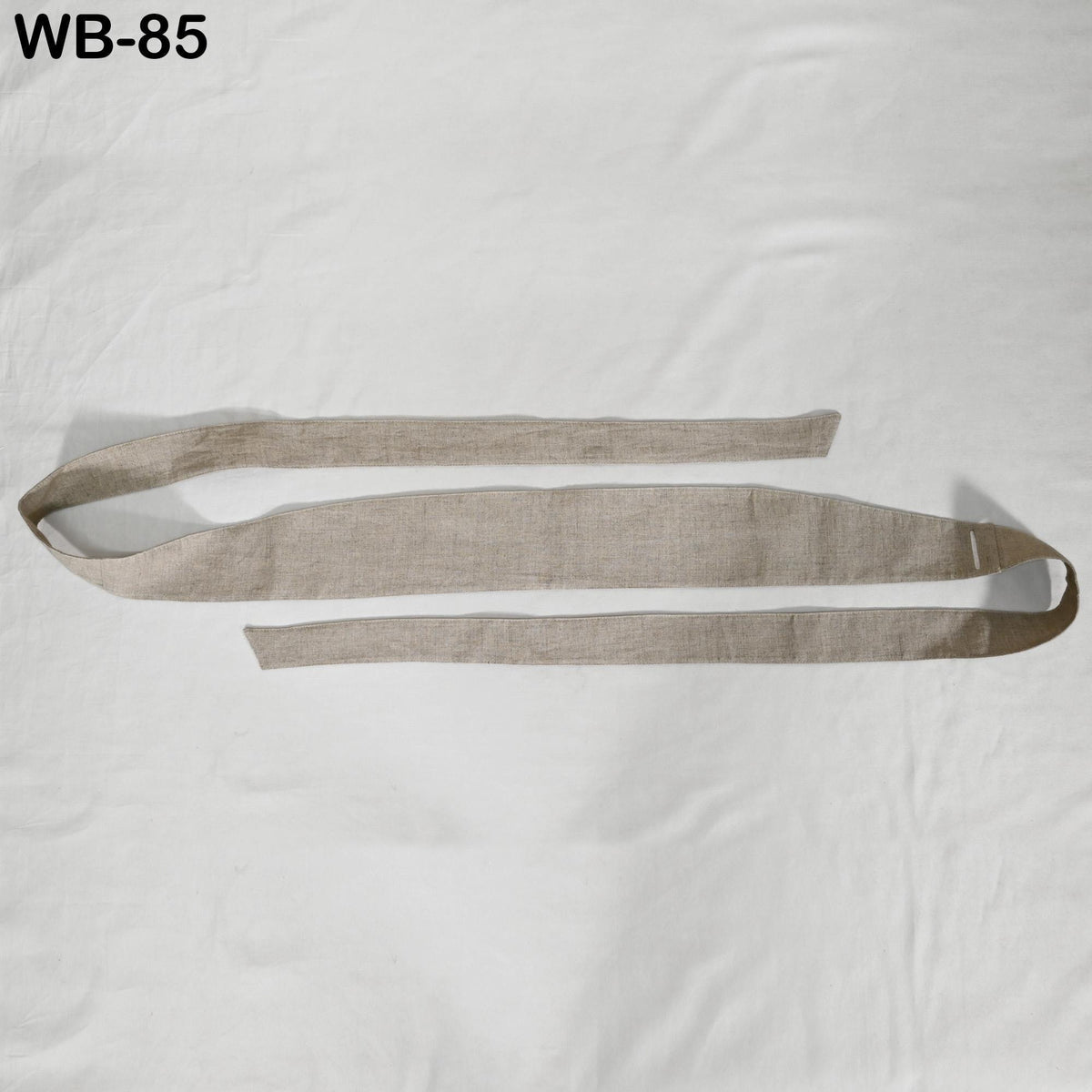 A beige fabric item, possibly a scarf or belt, is shown against a white background.