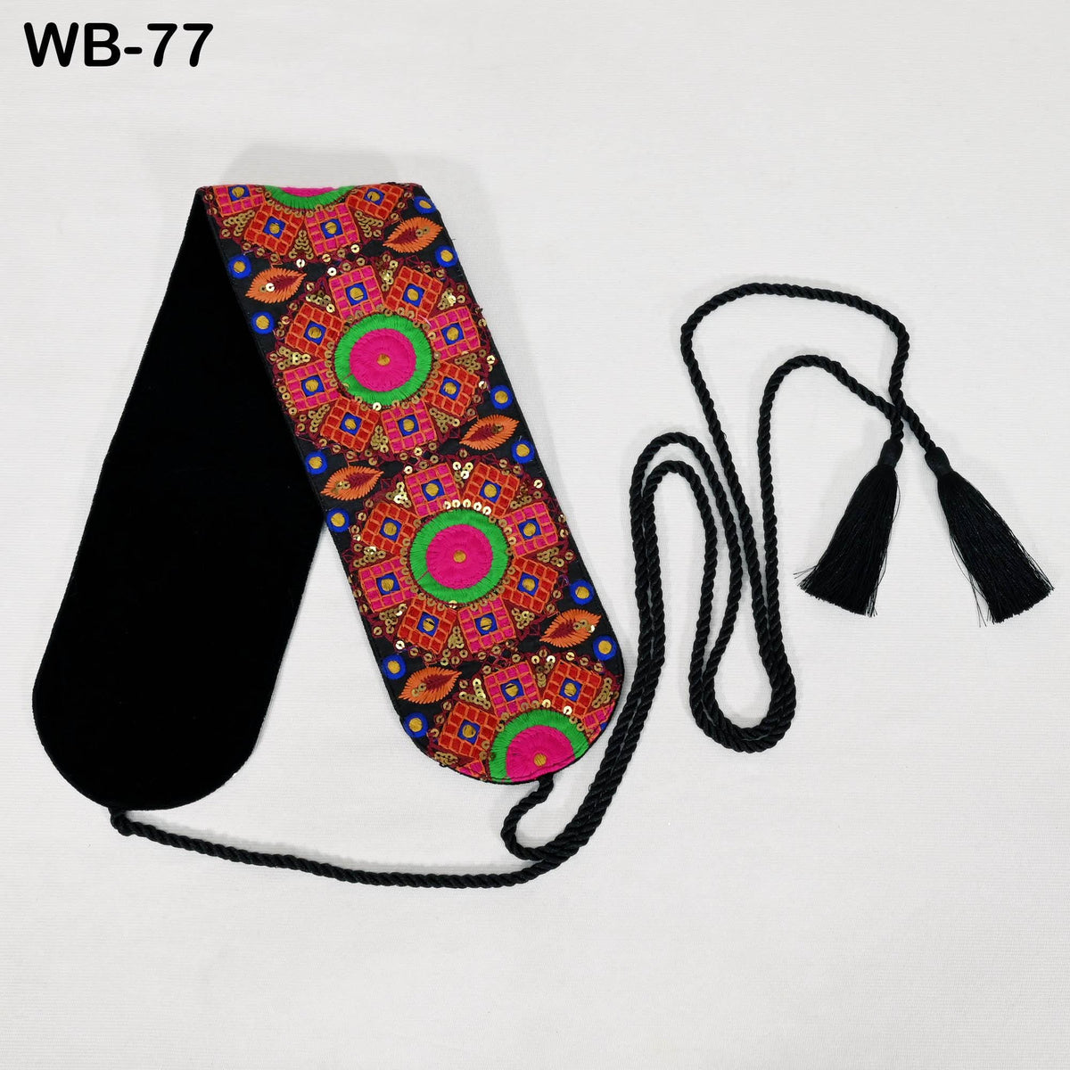 a colorful, patterned scarf with a black tassel hanging from it, placed on a white background.