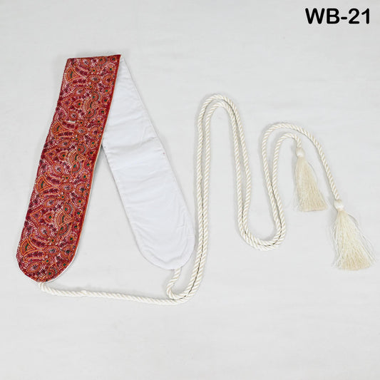 a red and white paisley-patterned scarf with a white tassel attached, lying on a white surface.