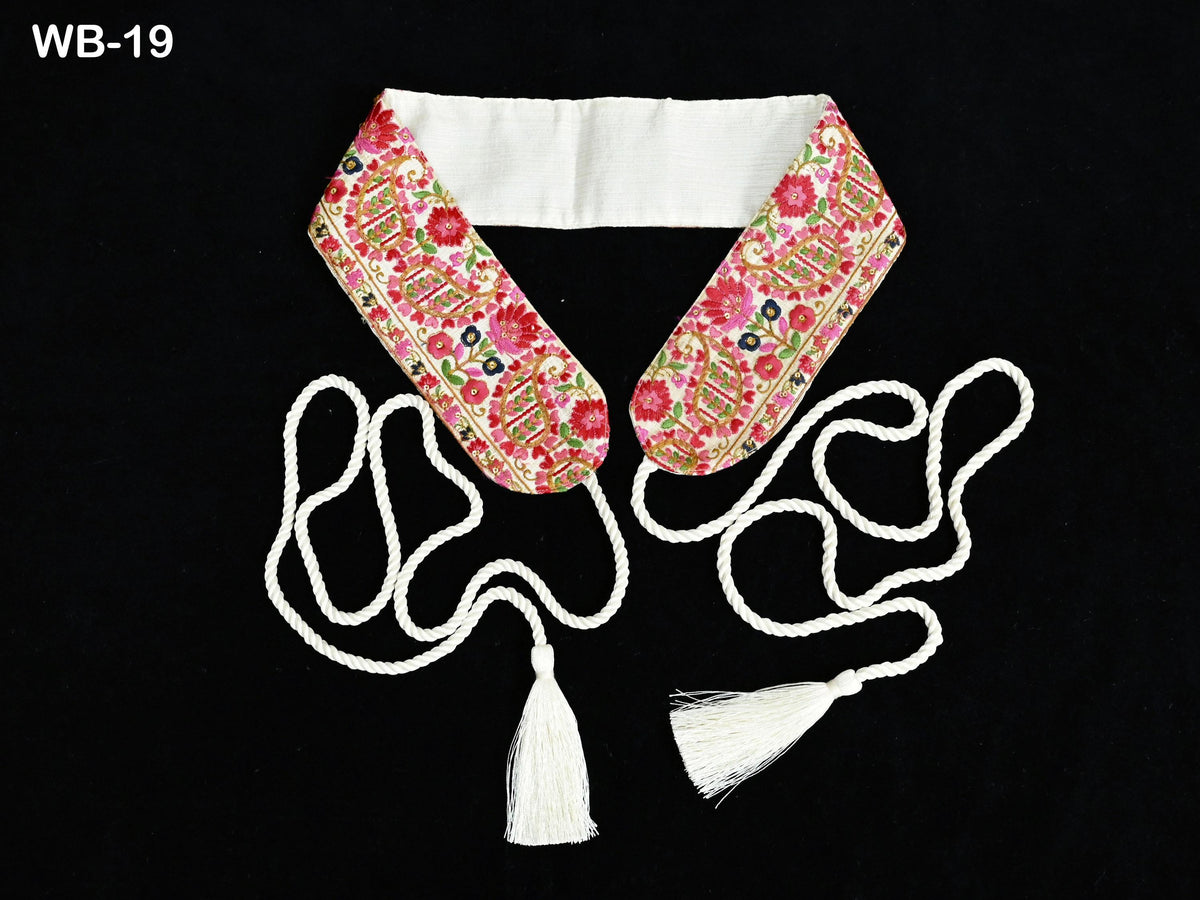 a floral-patterned collar with a white tassel attached to it, set against a black background.