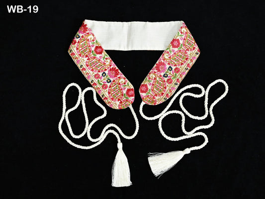 a floral-patterned collar with a white tassel attached to it, set against a black background.