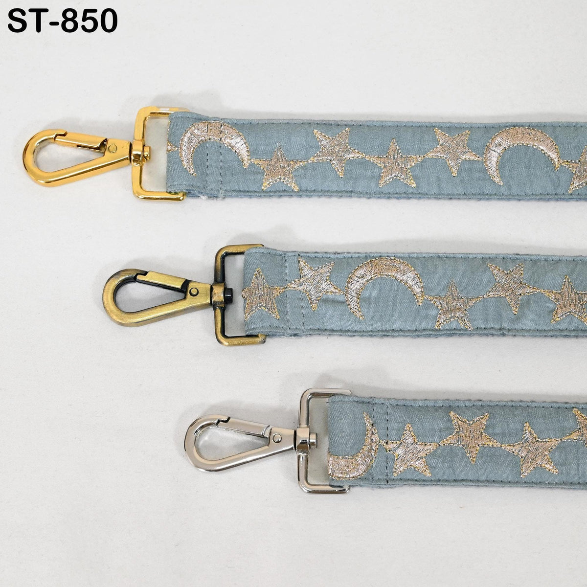 three different straps with star and crescent designs, each with a metal clasp and hook.