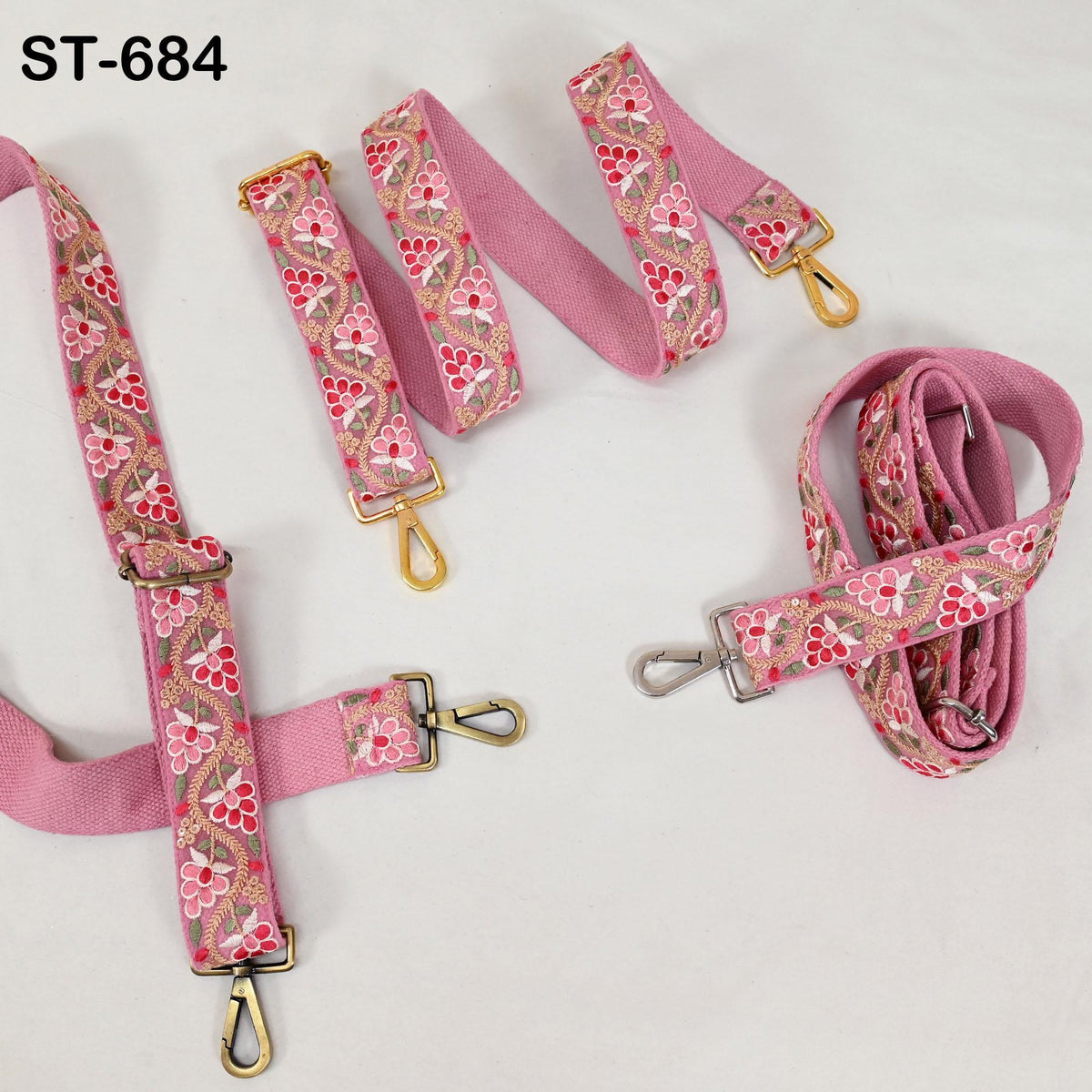a collection of pink floral straps with metal hooks, arranged on a white background.