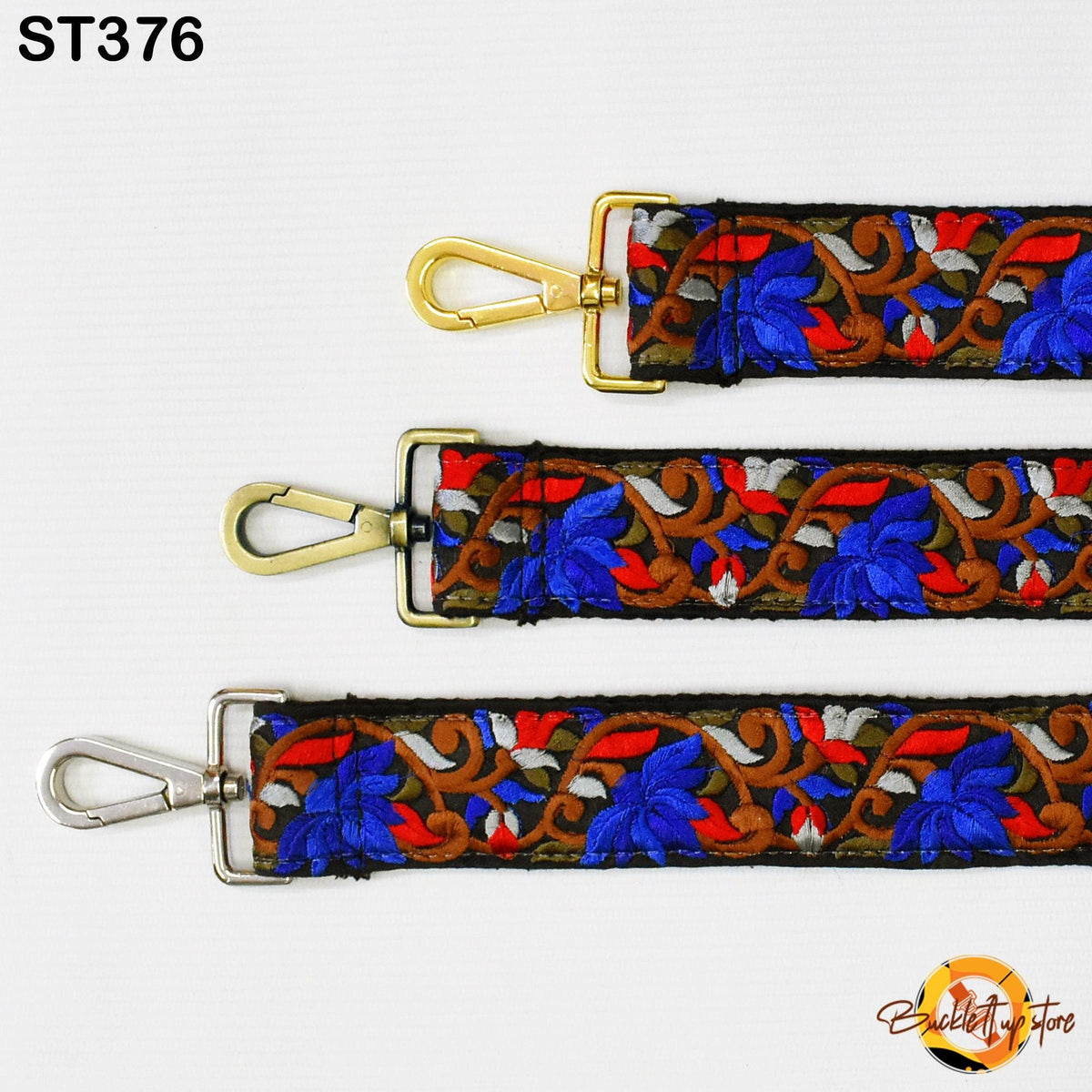 three colorful straps with gold buckles, each featuring a floral pattern in shades of blue, red, and brown.