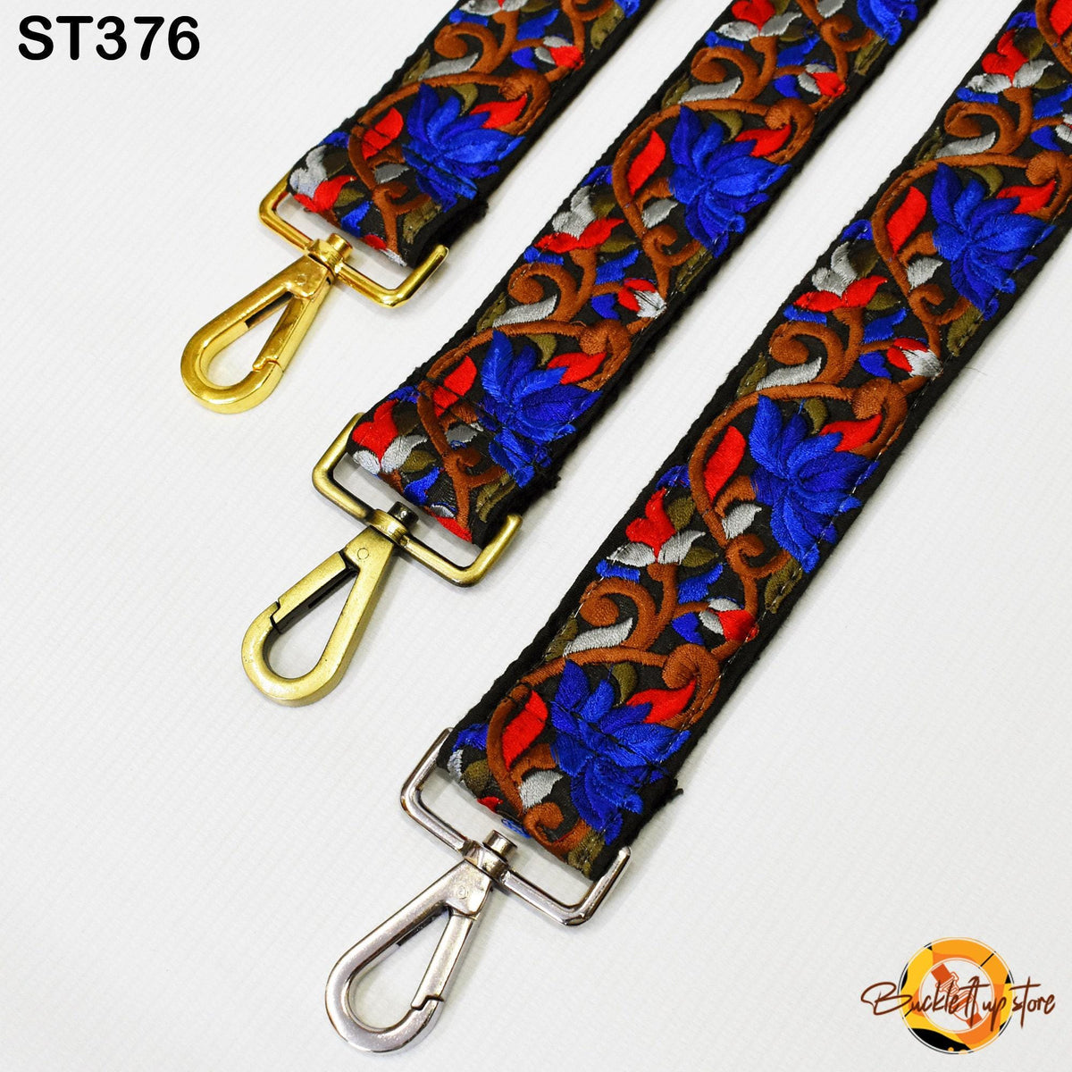 three colorful straps with floral patterns, each featuring a gold-colored metal loop. The straps appear to be made of fabric and are displayed against a white background.