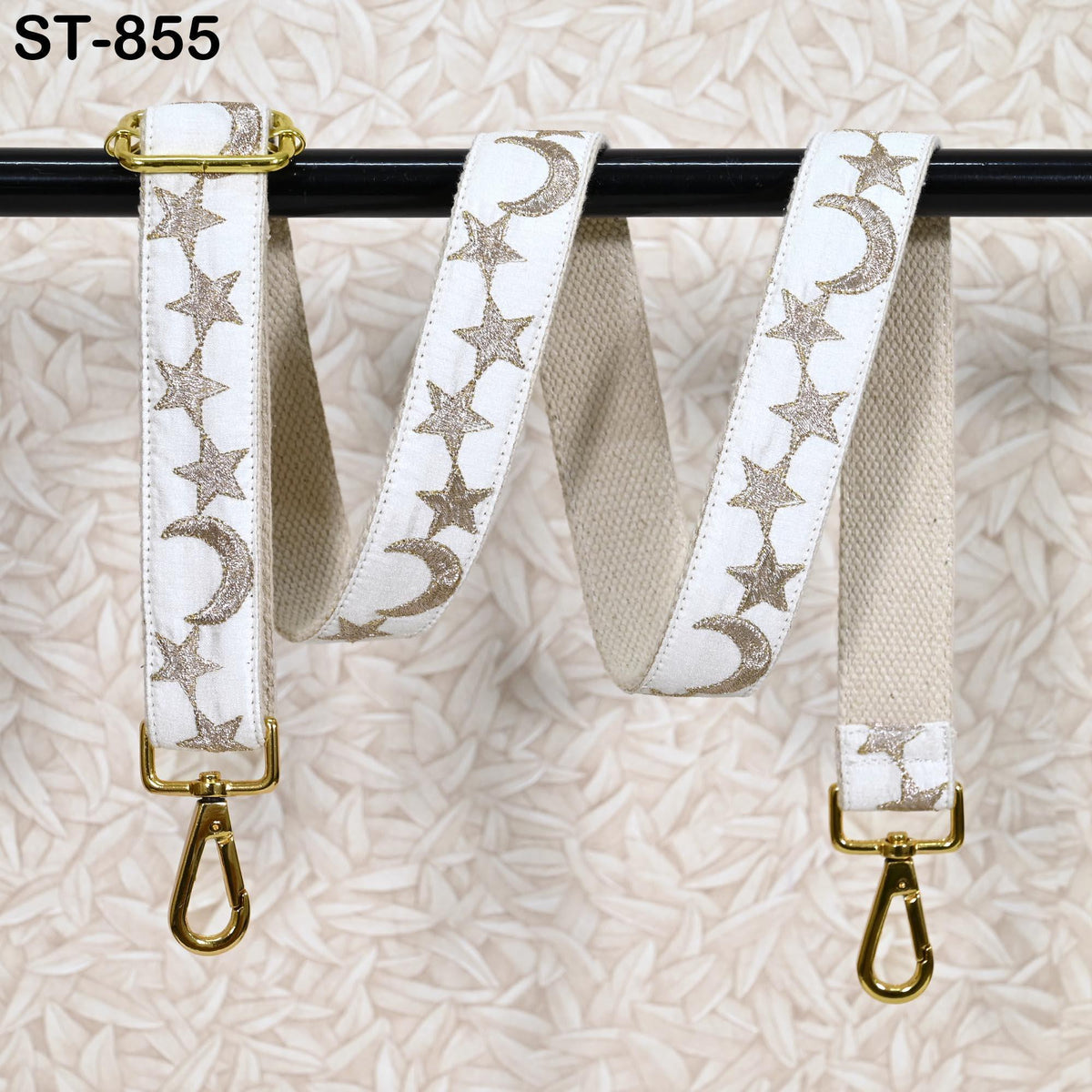 A white strap with gold star and crescent designs is hanging on a black pole.