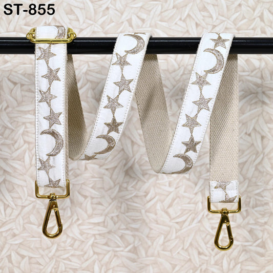 A white strap with gold star and crescent designs is hanging on a black pole.