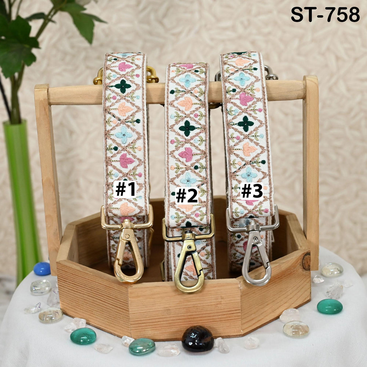 Three colorful straps with numbers on them, displayed in a wooden crate or holder.