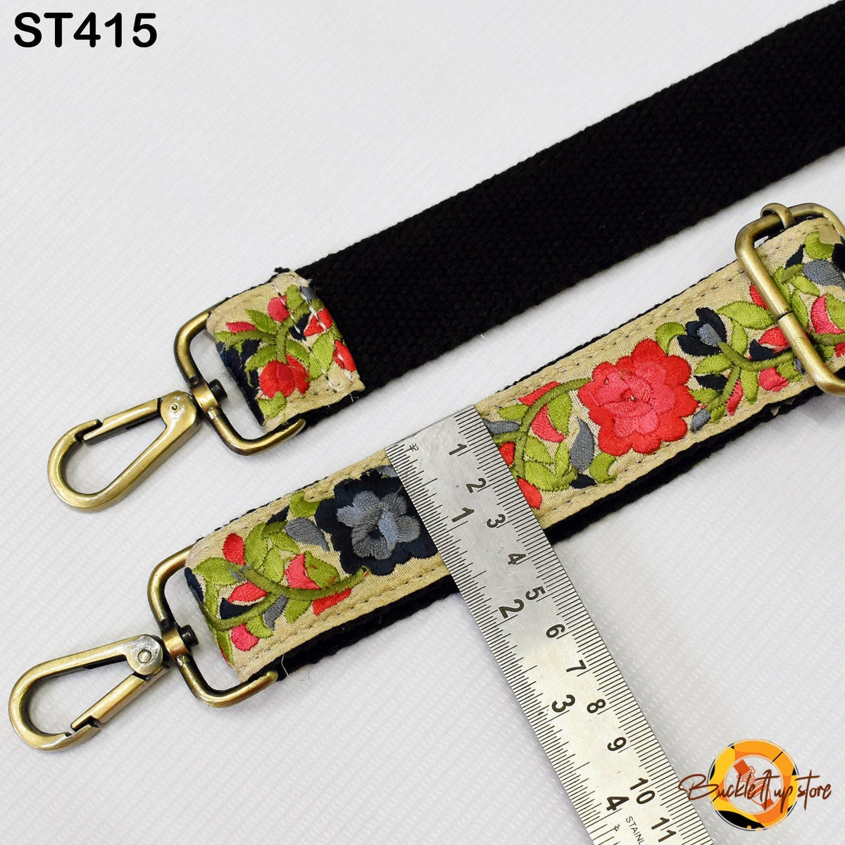 a floral-patterned strap with a black strap, a metal ruler, and a clasp.