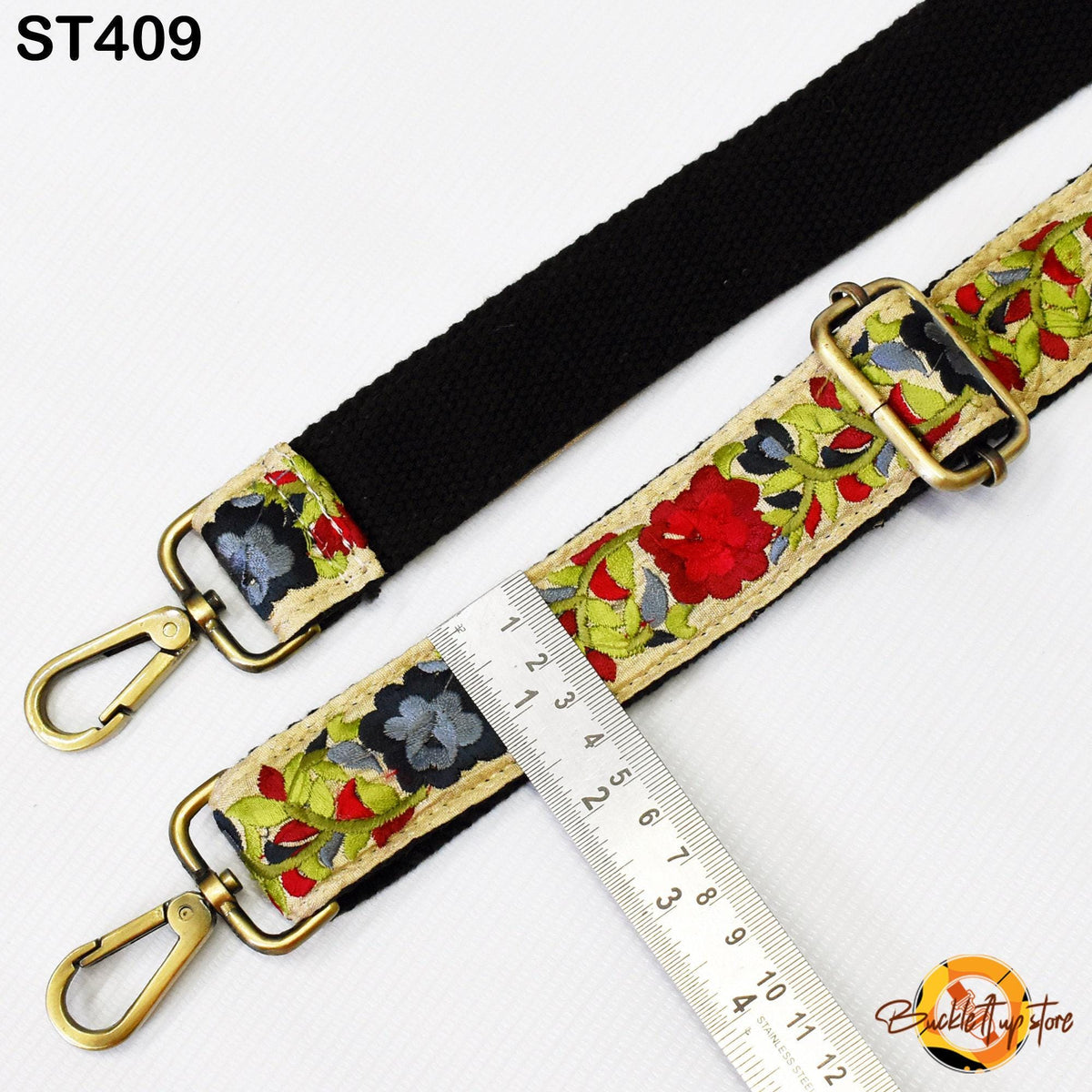 a black strap with a floral pattern and a ruler placed next to it, indicating the strap's size.