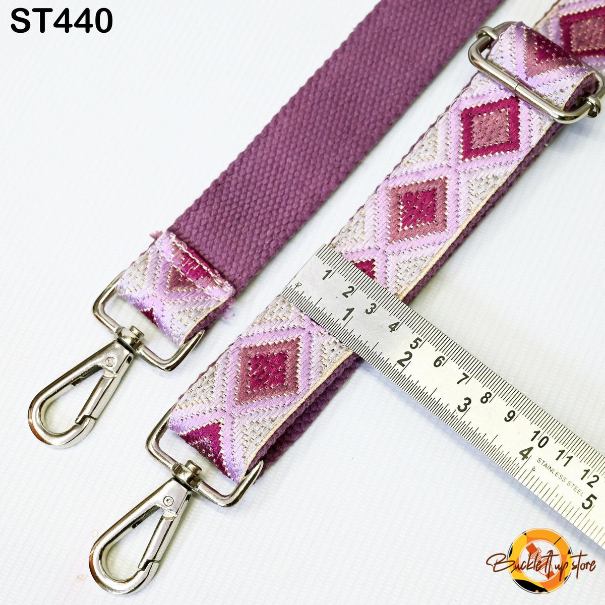 a purple strap with a diamond pattern, and a ruler is placed next to it, indicating the strap's length.