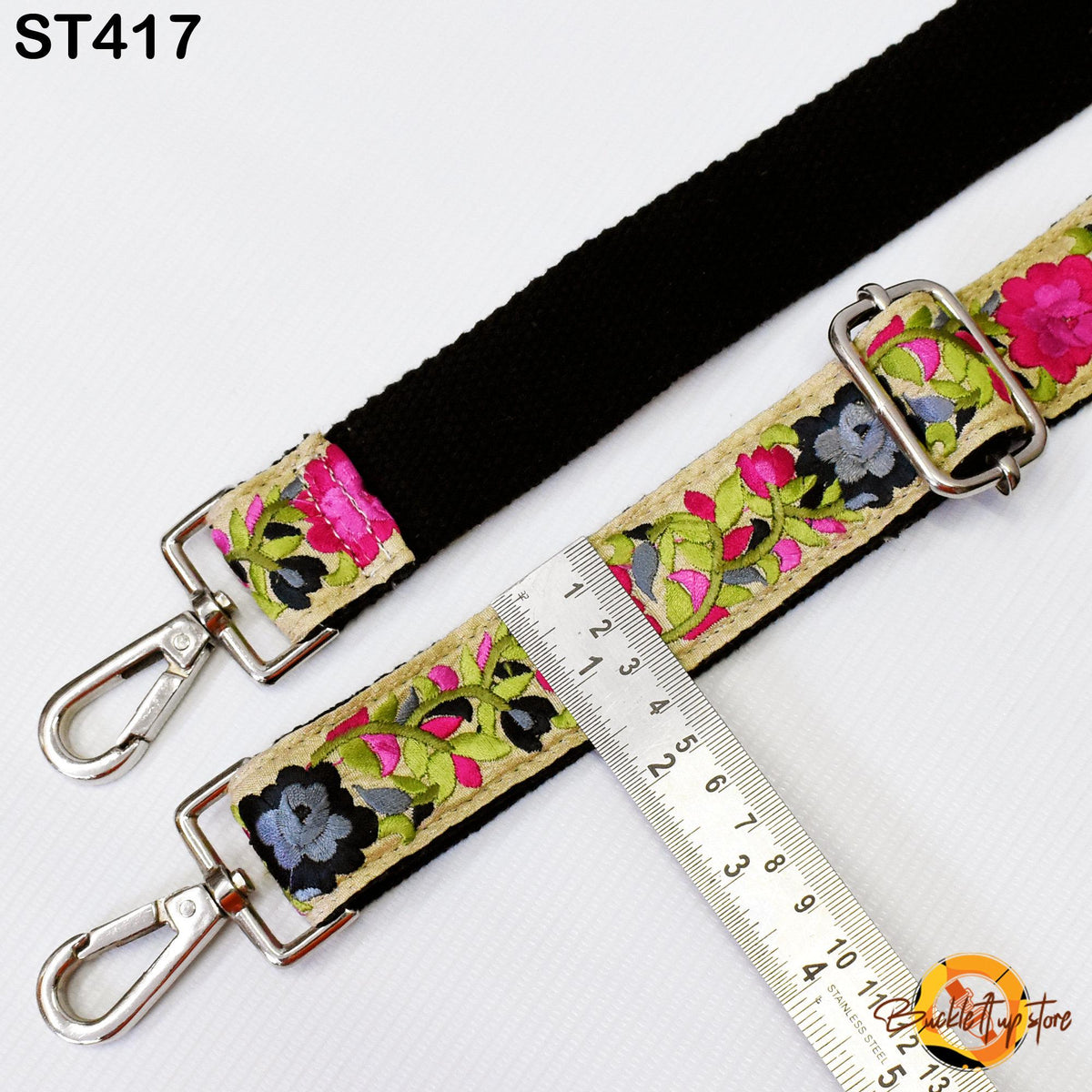 a floral-patterned strap with a black buckle, and a ruler is placed next to it, indicating the strap's length.