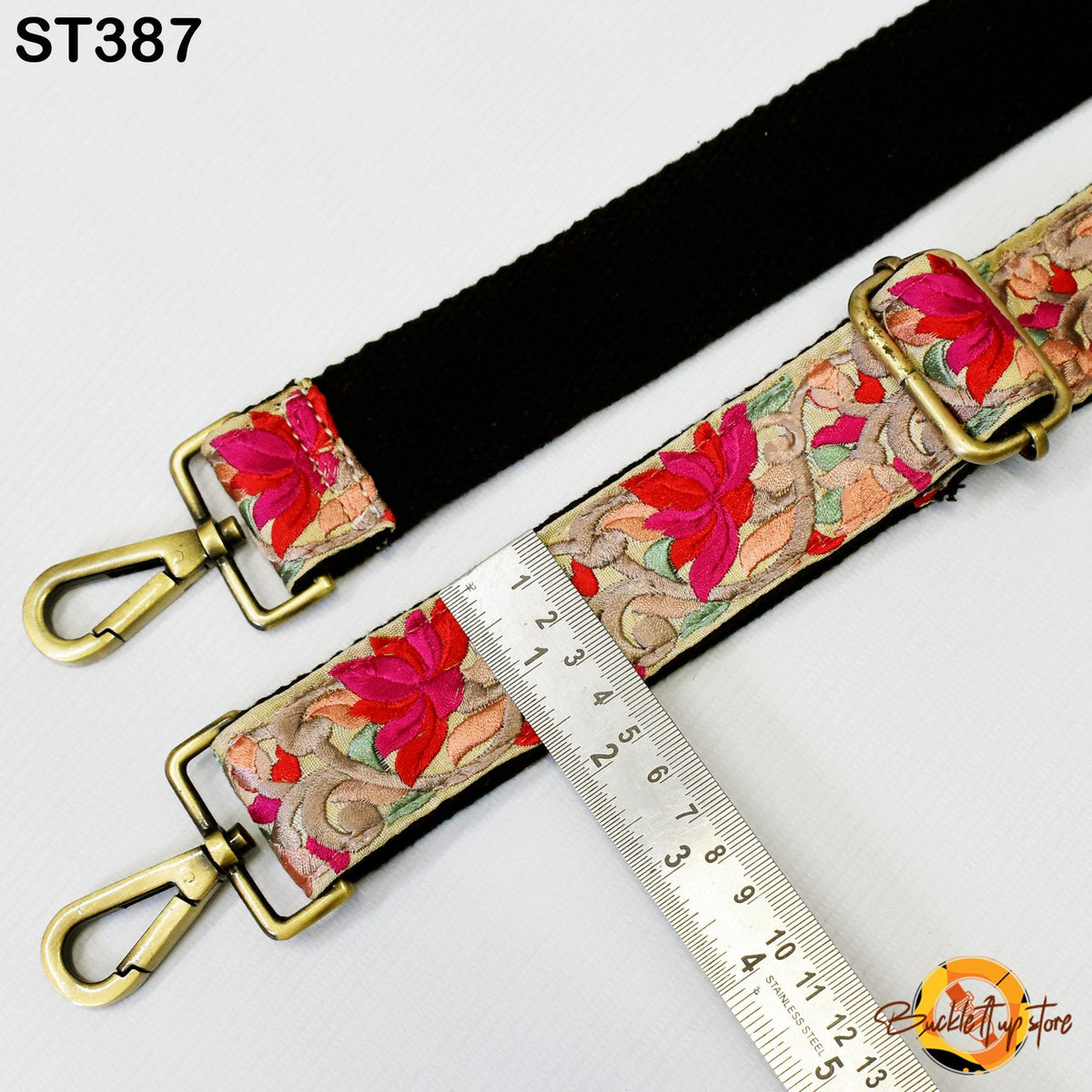 a floral patterned strap with a black strap, a ruler, and a clasp.