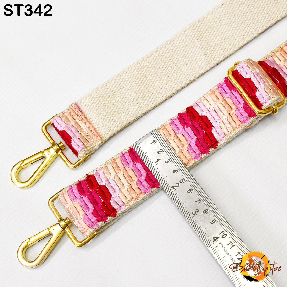 a strap with a colorful pattern, and a ruler is placed next to it, indicating the strap's length.
