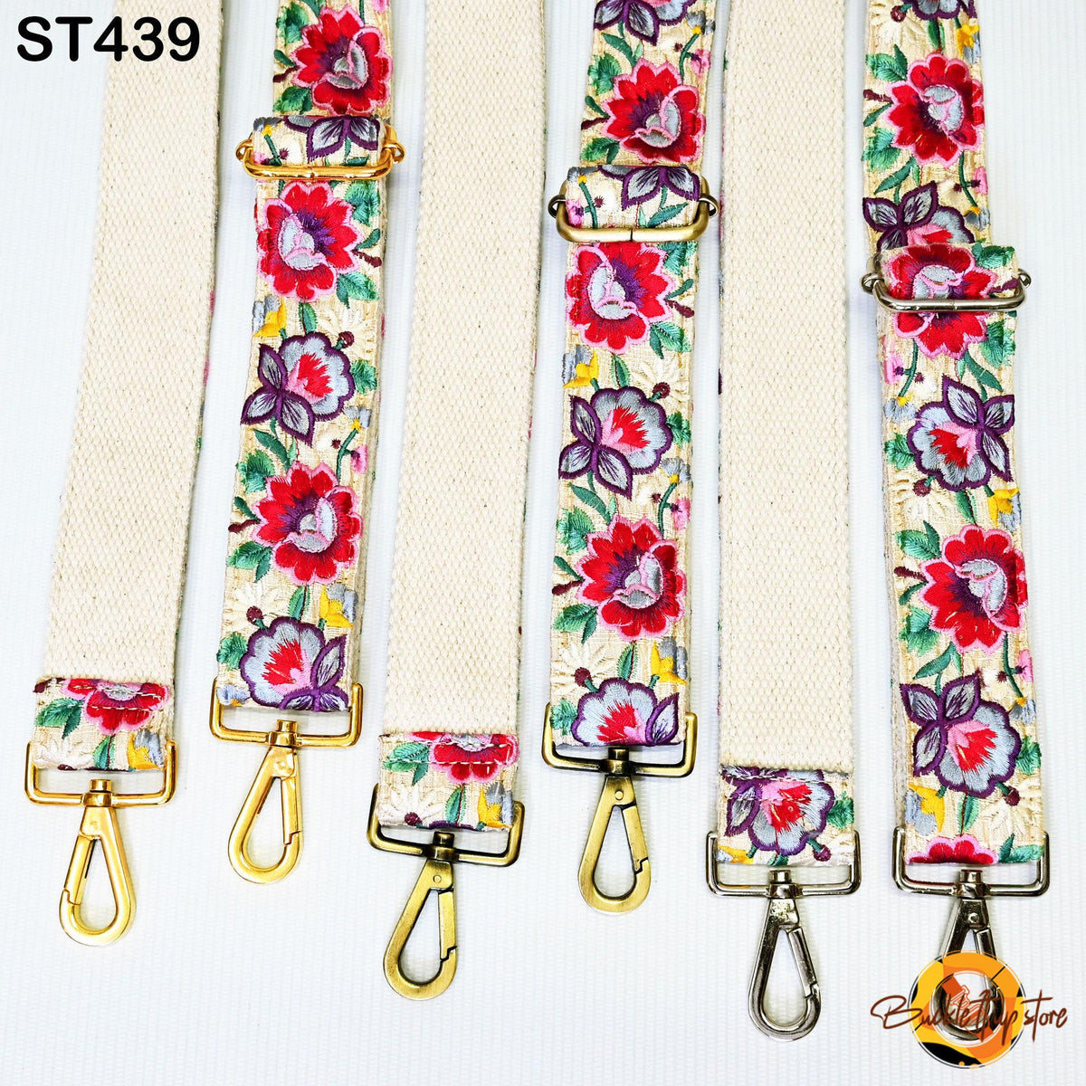 a collection of colorful floral straps, each with a gold metal buckle and hook. The straps are arranged in a row, showcasing their vibrant patterns and designs.