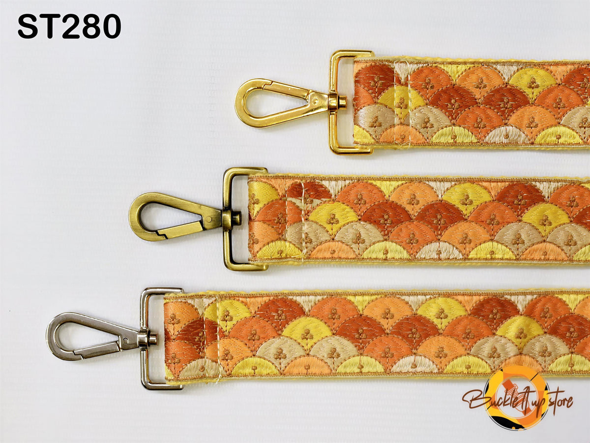 three straps with different patterns, including a gold-colored metal buckle and a colorful fabric strap.