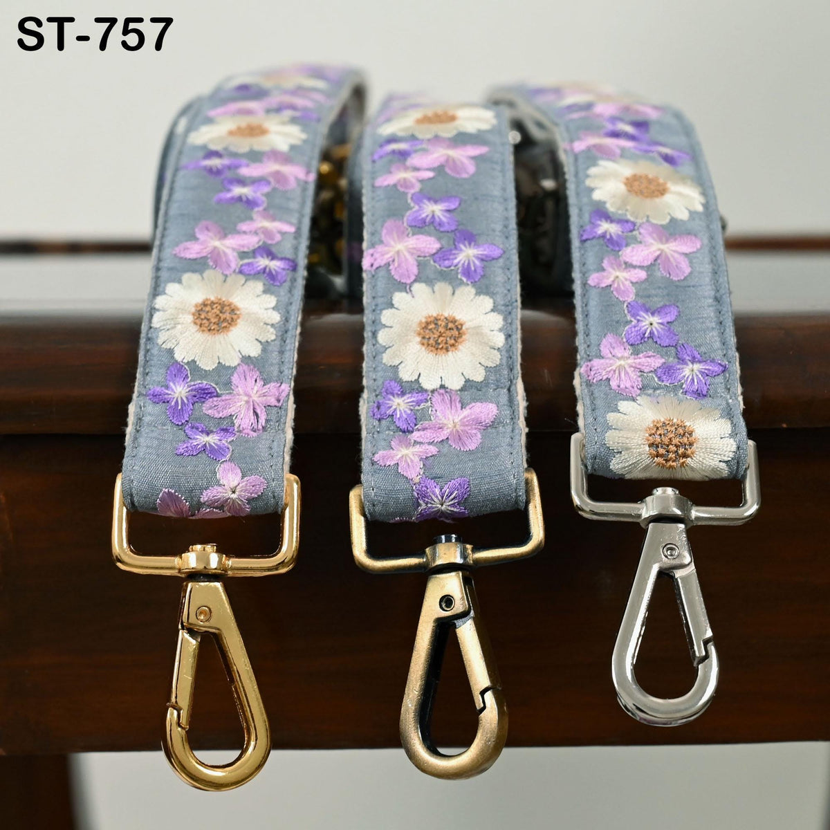 Three colorful straps with floral patterns are displayed on a wooden surface.