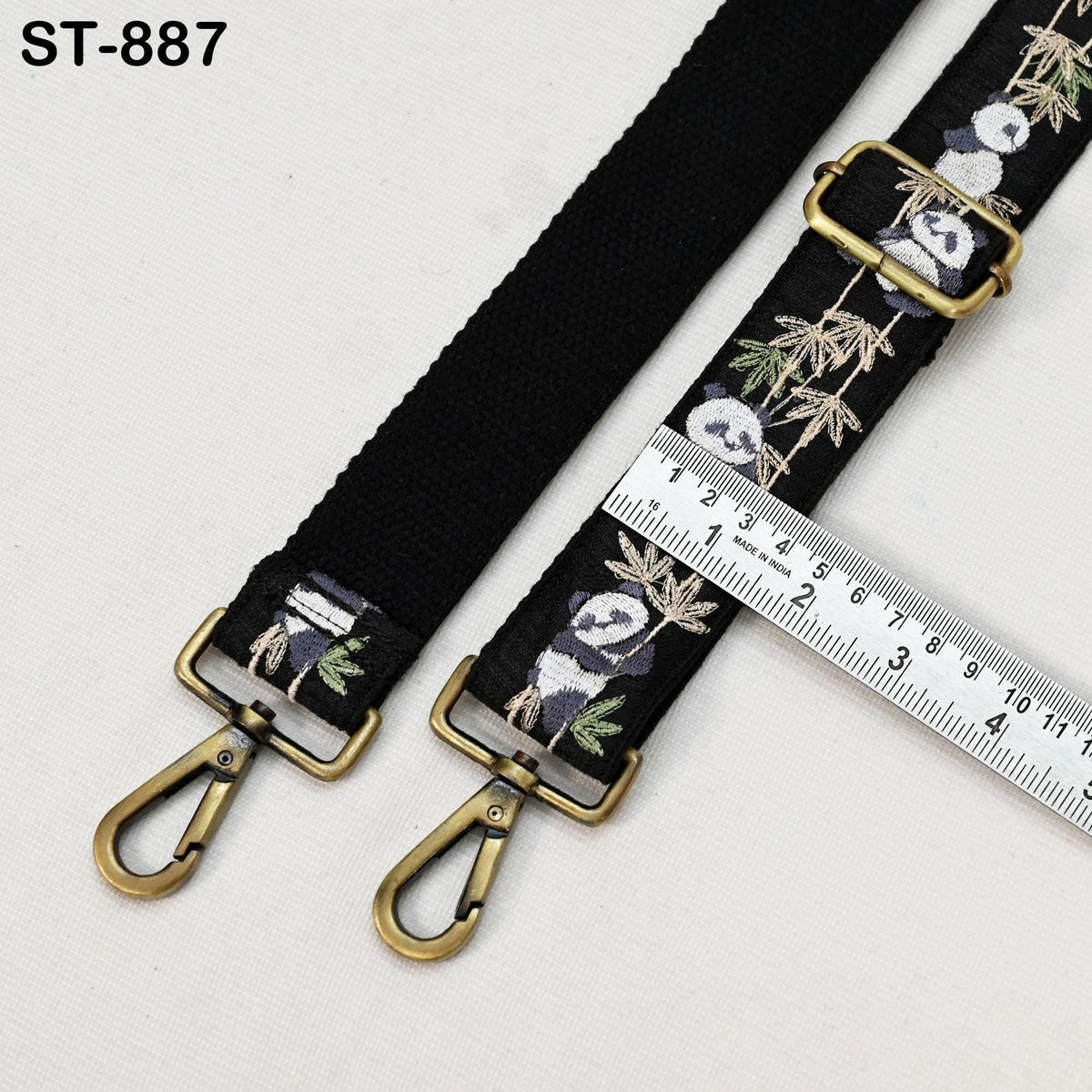 a black strap with a panda design, and a ruler is placed next to it, indicating the strap's length.