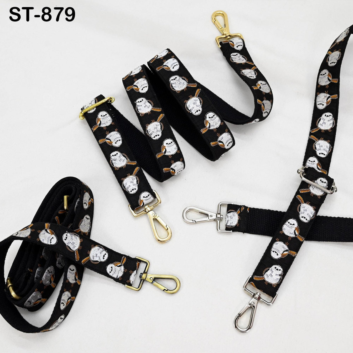 several black straps with a repeating pattern of white owls printed on them. The straps appear to be made of fabric and are designed for use as handbags or other accessories.
