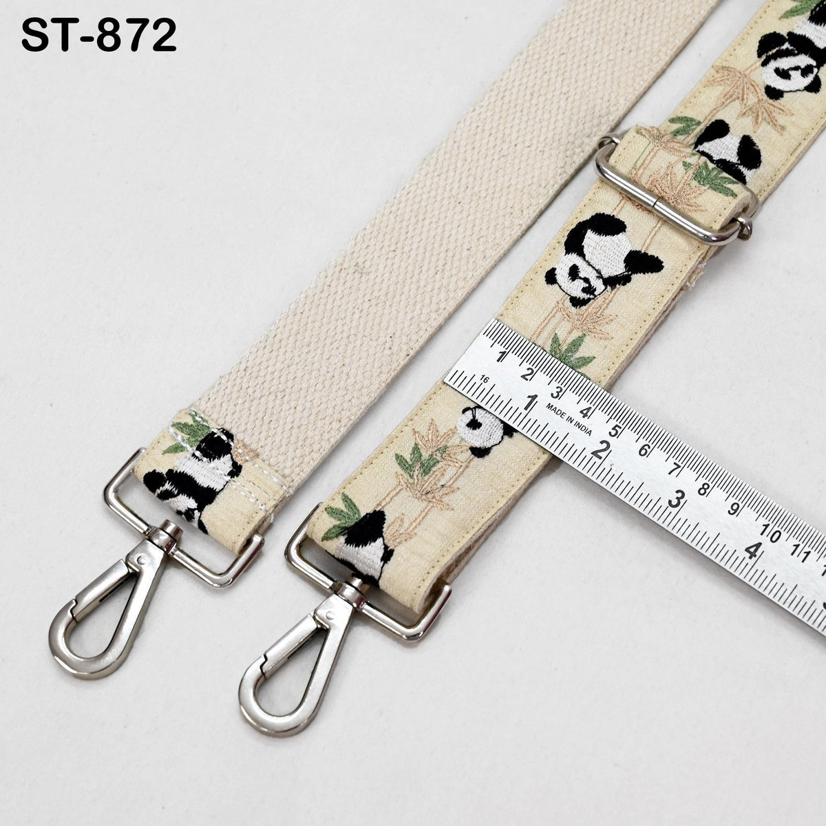 a beige strap with a panda design, featuring a metal buckle and a ruler for size comparison.