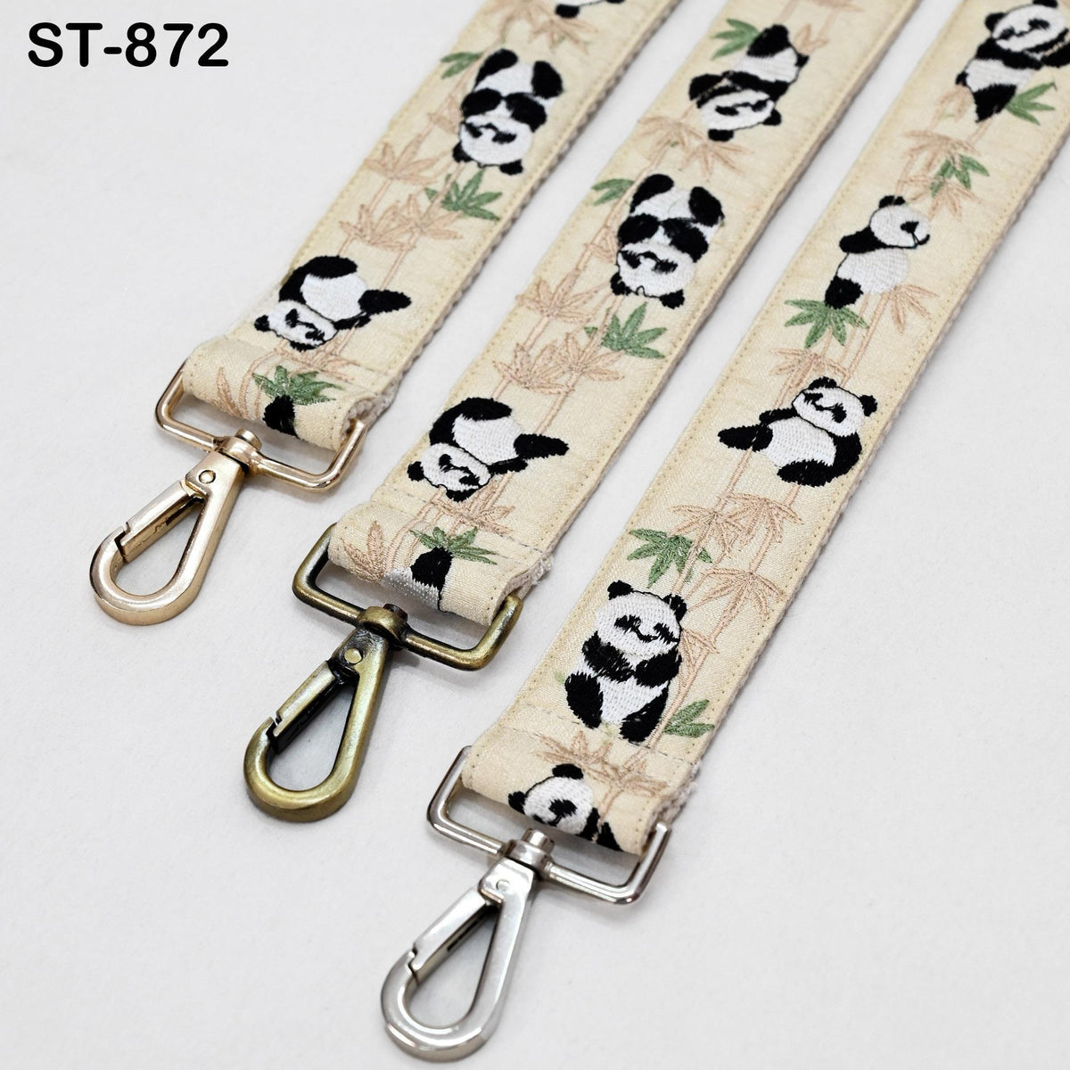 three beige straps with a panda bear pattern, each with a metal clasp and hook at the end.