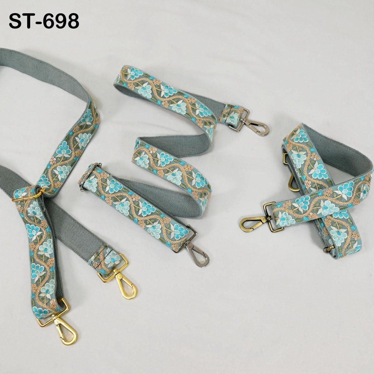 A collection of patterned fabric straps with metal hardware, including buckles and clips, arranged on a white background.