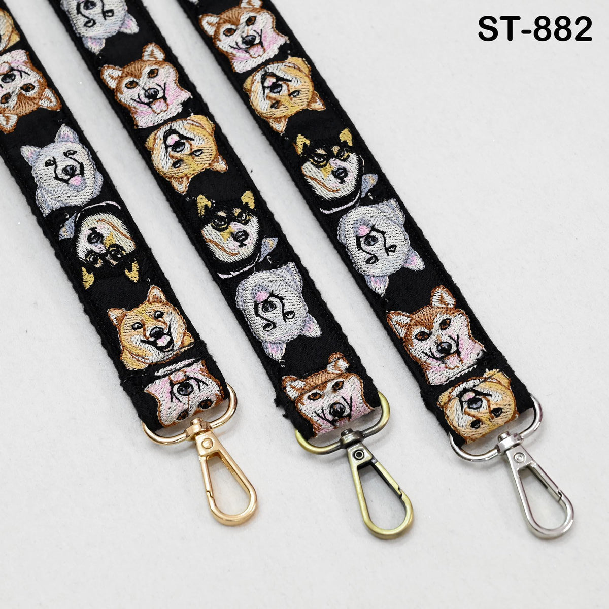three straps with dog faces printed on them, each with a metal hook at the end.