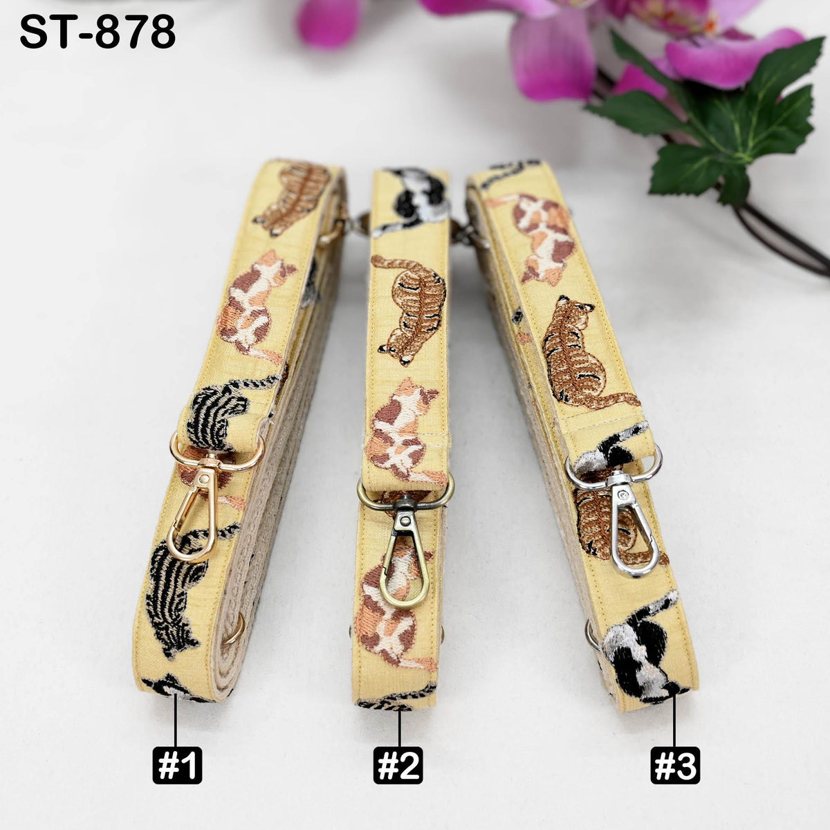 Three leopard print straps with cat designs, each with a metal clasp and loop, are displayed on a white background.
