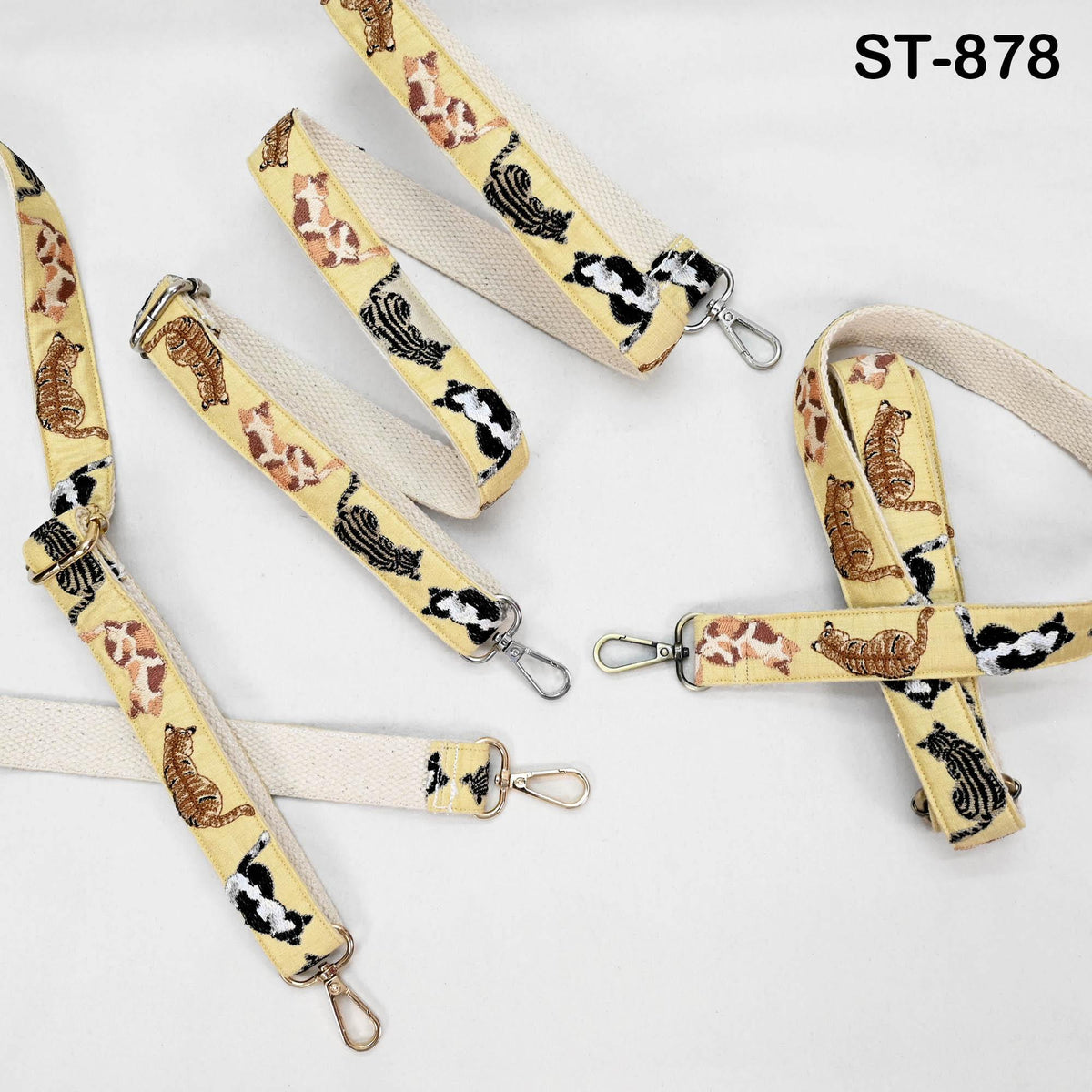 a collection of cat-themed straps or leashes, each with a unique design featuring cats in various poses and colors.